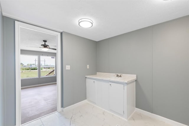 754 Altwein Ln, New Braunfels, TX 78130 - washroom featuring a textured ceiling, light marble finish flooring, ceiling fan, and a decorative wall