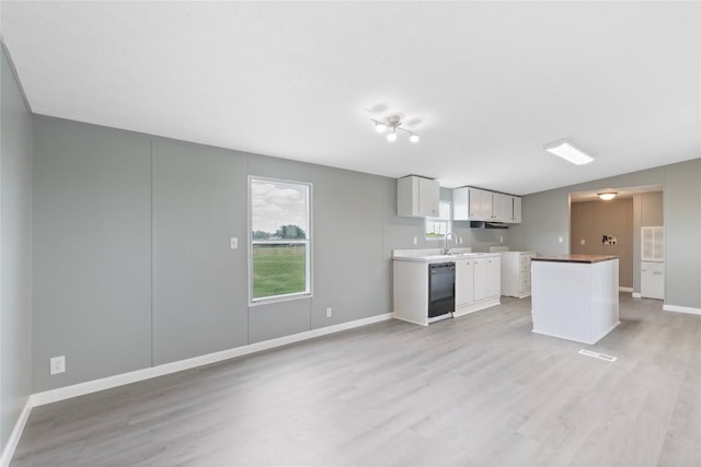 754 Altwein Ln, New Braunfels, TX 78130 - kitchen with light wood-style flooring, black dishwasher, a kitchen island, light countertops, and white cabinets