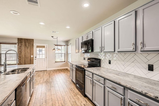 400 Hummingbird Ln, Leander, TX 78641 - kitchen featuring black appliances, gray cabinetry, backsplash, recessed lighting, and light wood-style flooring