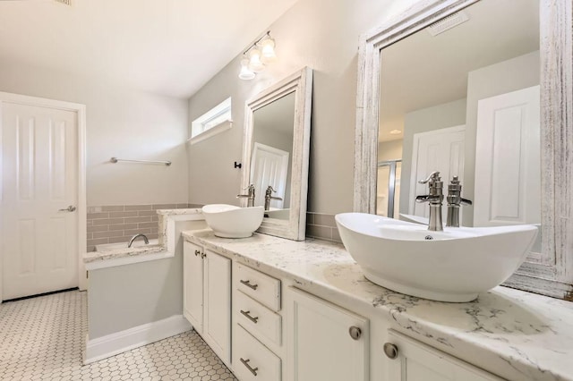 400 Hummingbird Ln, Leander, TX 78641 - bathroom featuring double vanity, a garden tub, and a shower with shower door