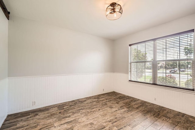 400 Hummingbird Ln, Leander, TX 78641 - empty room featuring wood finished floors and a wainscoted wall