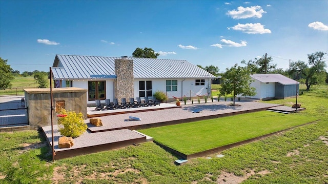 19811 W Ranch Road 152nd Rd, Llano, TX 78643 - back of house with a standing seam roof, a chimney, a metal roof, a lawn, and a patio area