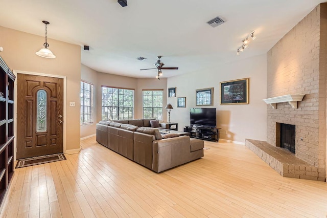 4513 Sidereal Dr, Austin, TX 78727 - living area with a ceiling fan, a brick fireplace, and wood-type flooring
