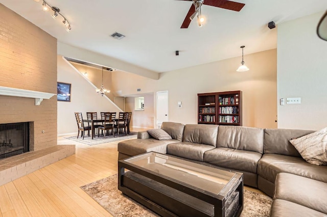 4513 Sidereal Dr, Austin, TX 78727 - living area featuring ceiling fan, hardwood / wood-style floors, a brick fireplace, and a chandelier