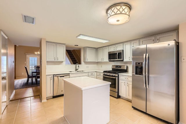 4513 Sidereal Dr, Austin, TX 78727 - kitchen with appliances with stainless steel finishes, light countertops, a center island, light tile patterned floors, and gray cabinets