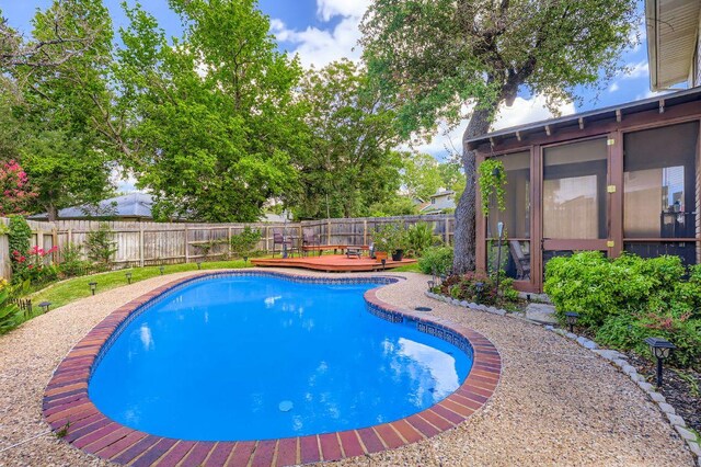 4513 Sidereal Dr, Austin, TX 78727 - view of pool with a wooden deck, a fenced backyard, and a sunroom
