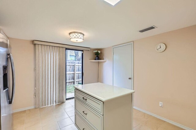 4513 Sidereal Dr, Austin, TX 78727 - kitchen featuring stainless steel fridge with ice dispenser, light countertops, and a center island