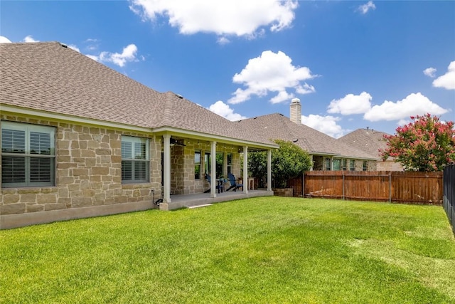 3204 Herrero Path, Cedar Park, TX 78641 - back of house featuring a fenced backyard, stone siding, roof with shingles, a patio area, and a chimney