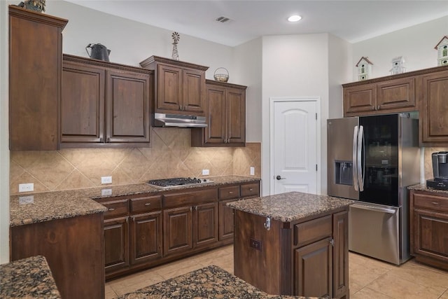 3204 Herrero Path, Cedar Park, TX 78641 - kitchen with stainless steel appliances, under cabinet range hood, dark stone countertops, light tile patterned floors, and recessed lighting