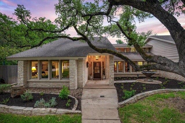 10601 Spicewood Pkwy, Austin, TX 78750 - view of front facade featuring stone siding and roof with shingles