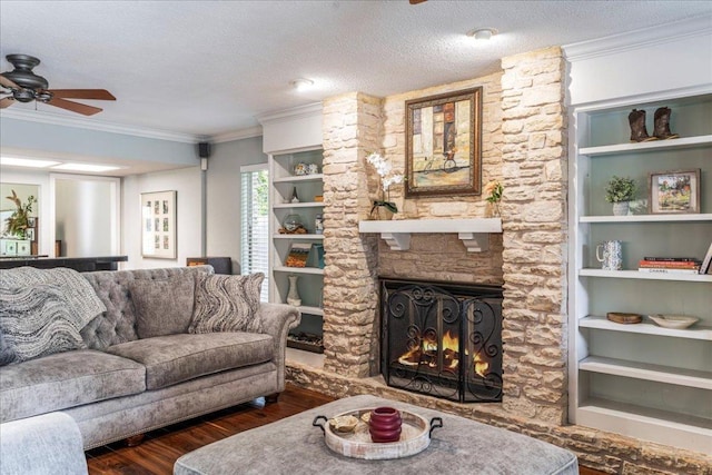 10601 Spicewood Pkwy, Austin, TX 78750 - living room featuring wood finished floors, ceiling fan, ornamental molding, a stone fireplace, and a textured ceiling