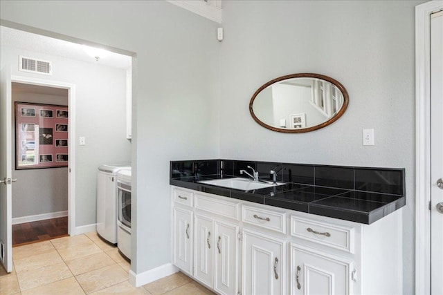 10601 Spicewood Pkwy, Austin, TX 78750 - laundry room with washer and dryer, light tile patterned floors, and cabinet space
