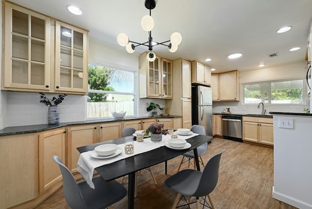 9224 Partridge Cir, Austin, TX 78758 - kitchen featuring stainless steel appliances, light brown cabinets, decorative backsplash, dark countertops, and recessed lighting