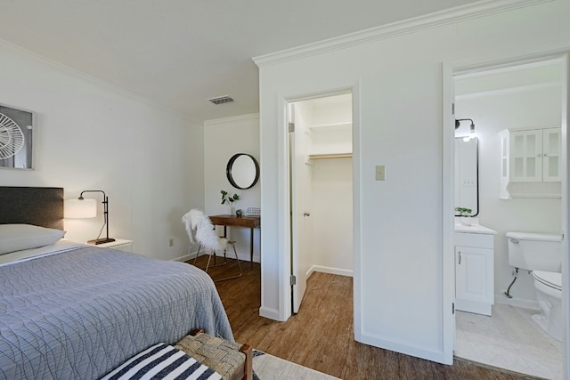 9224 Partridge Cir, Austin, TX 78758 - bedroom with a walk in closet, ornamental molding, wood finished floors, and a closet