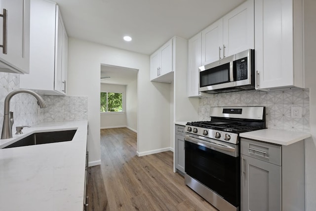 4803 Broadhill Dr, Austin, TX 78723 - kitchen featuring appliances with stainless steel finishes, light wood-style floors, backsplash, recessed lighting, and white cabinetry