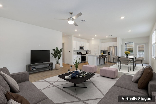 13804 Bavarian Forest Dr, Pflugerville, TX 78660 - living room with light wood finished floors, a ceiling fan, and recessed lighting