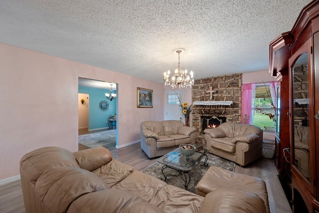 1121 Nola Ruth Blvd, Harker Heights, TX 76548 - living area with a chandelier, a textured ceiling, wood finished floors, and a stone fireplace
