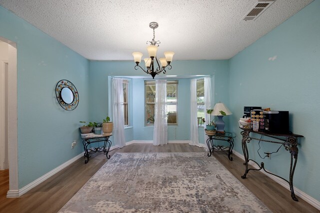 1121 Nola Ruth Blvd, Harker Heights, TX 76548 - sitting room with wood finished floors, a chandelier, arched walkways, and a textured ceiling