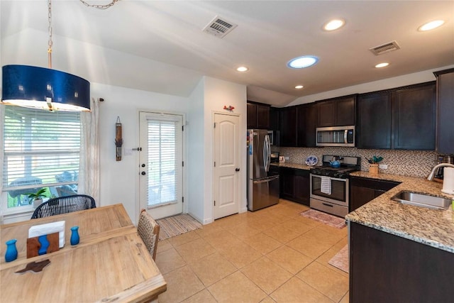 13920 Marathon Rd, Austin, TX 78717 - kitchen with stainless steel appliances, light stone counters, decorative backsplash, light tile patterned floors, and dark brown cabinets