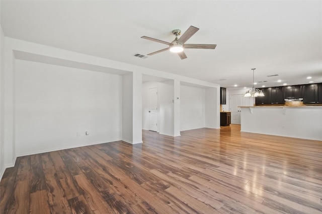 2017 Woodway Dr, Leander, TX 78641 - unfurnished living room featuring ceiling fan, wood finished floors, recessed lighting, and a chandelier