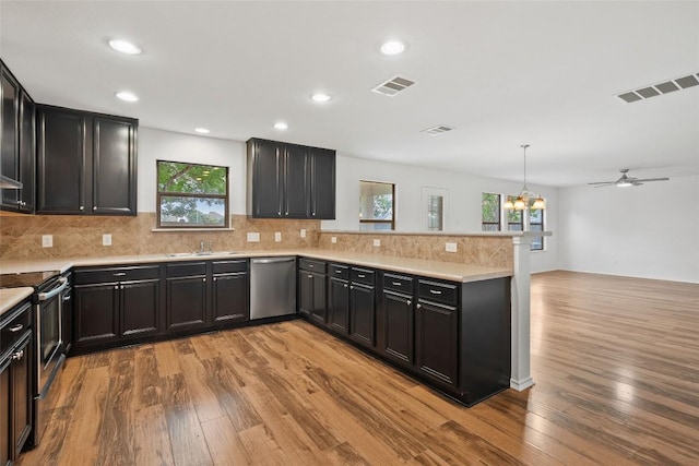 2017 Woodway Dr, Leander, TX 78641 - kitchen featuring stainless steel appliances, a peninsula, light wood-style floors, healthy amount of natural light, and recessed lighting