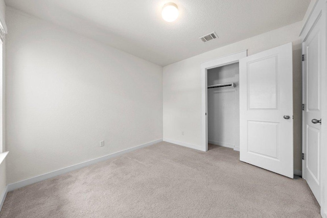 136 Gidran Trl, Georgetown, TX 78626 - unfurnished bedroom with light colored carpet, a closet, and a textured ceiling