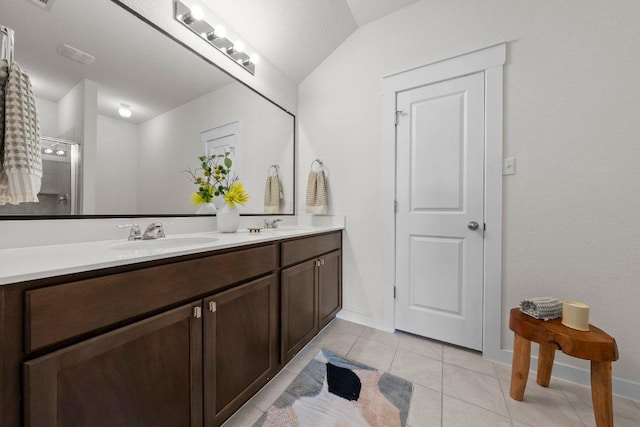 136 Gidran Trl, Georgetown, TX 78626 - bathroom featuring double vanity, tile patterned floors, an enclosed shower, and lofted ceiling