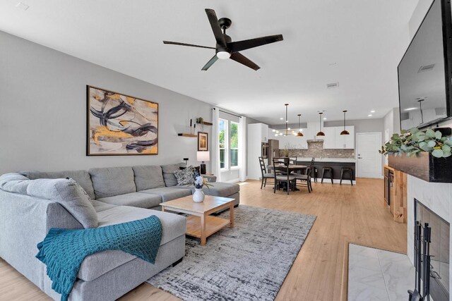 800 Sand Hill Branch Dr Unit 38, Austin, TX 78748 - living area featuring ceiling fan, light wood-style floors, a chandelier, recessed lighting, and a tile fireplace