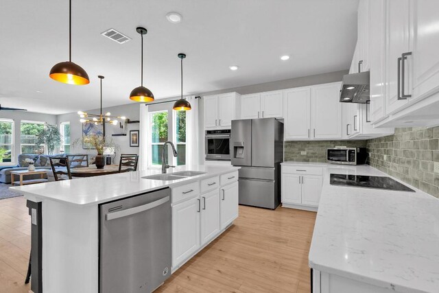 800 Sand Hill Branch Dr Unit 38, Austin, TX 78748 - kitchen featuring stainless steel appliances, wall chimney range hood, open floor plan, backsplash, and white cabinetry