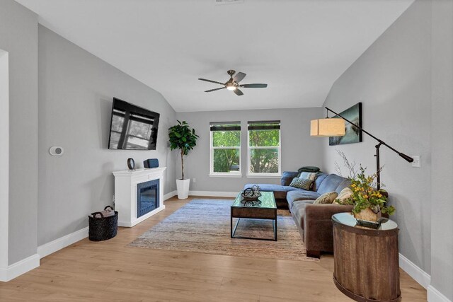 800 Sand Hill Branch Dr Unit 38, Austin, TX 78748 - living area featuring vaulted ceiling, a ceiling fan, light wood finished floors, and a glass covered fireplace