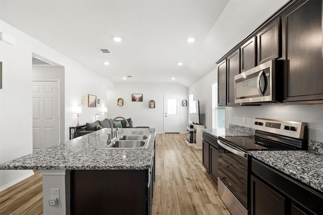 1037 Oxford Ln, Troy, TX 76579 - kitchen featuring stainless steel appliances, light wood-style floors, open floor plan, dark brown cabinetry, and recessed lighting
