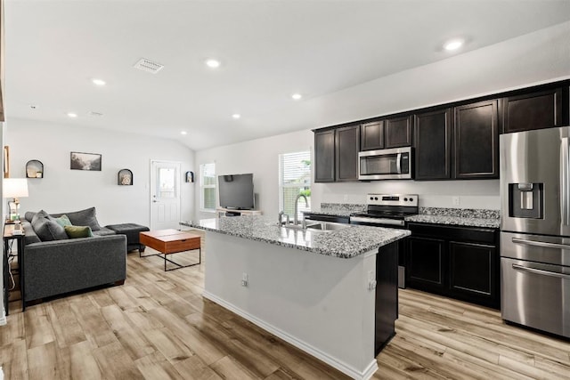 1037 Oxford Ln, Troy, TX 76579 - kitchen featuring stainless steel appliances, open floor plan, light wood finished floors, light stone countertops, and recessed lighting