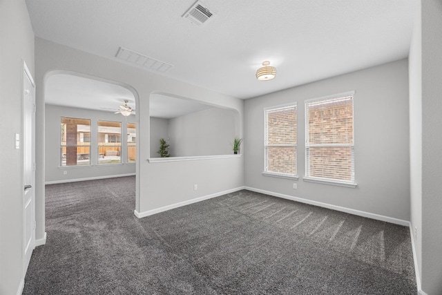 1236 Yellow Iris Rd, Leander, TX 78641 - spare room with dark carpet, arched walkways, and ceiling fan