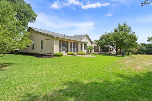 101 Goldenrod Way, Georgetown, TX 78633 - rear view of house featuring a sunroom, a lawn, and stucco siding