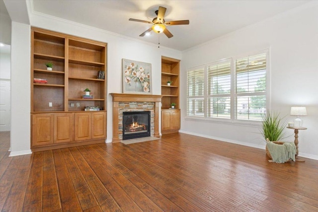 101 Goldenrod Way, Georgetown, TX 78633 - unfurnished living room featuring dark wood-style flooring, ceiling fan, a stone fireplace, and ornamental molding