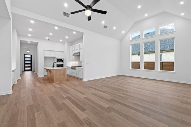 2113 Tobiano Trce, Georgetown, TX 78633 - unfurnished living room with a ceiling fan, high vaulted ceiling, light wood-type flooring, and recessed lighting