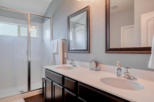 125 Lillian Dr, Taylor, TX 76574 - full bath featuring a stall shower, a textured wall, and double vanity