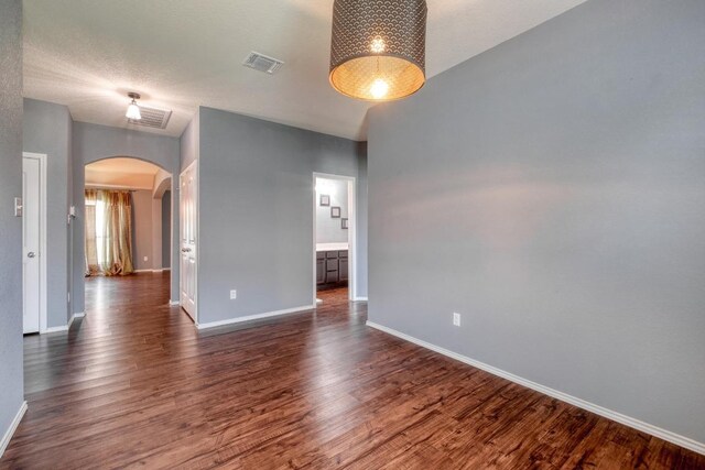 125 Lillian Dr, Taylor, TX 76574 - empty room with arched walkways and dark wood-style floors