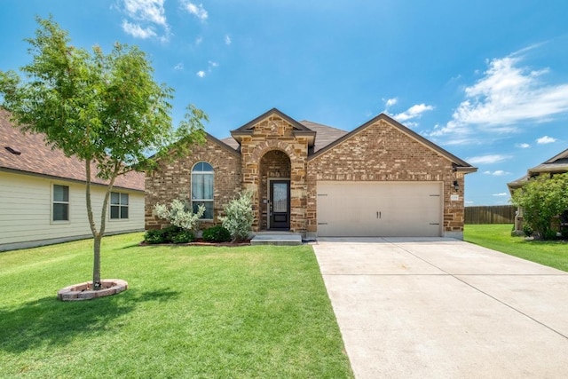 125 Lillian Dr, Taylor, TX 76574 - traditional-style house with an attached garage, a front yard, driveway, and brick siding