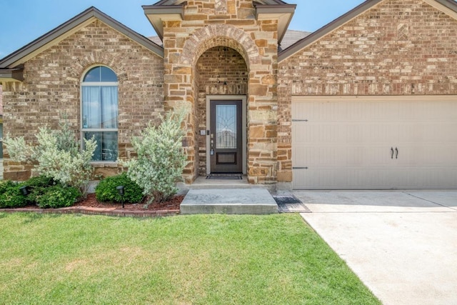 125 Lillian Dr, Taylor, TX 76574 - doorway to property with brick siding, a garage, a lawn, driveway, and stone siding