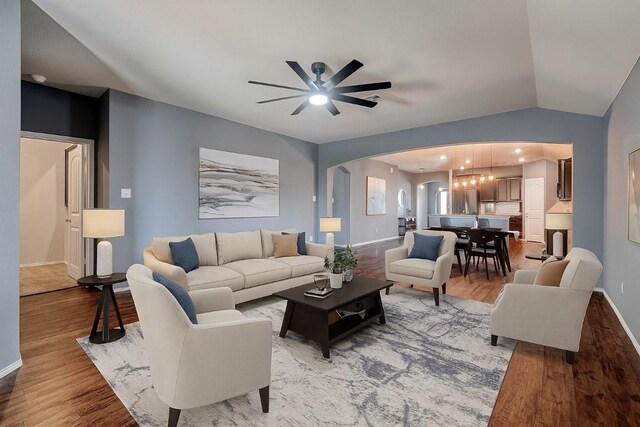 125 Lillian Dr, Taylor, TX 76574 - living area featuring arched walkways, light wood finished floors, a ceiling fan, and vaulted ceiling