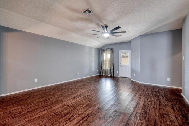 125 Lillian Dr, Taylor, TX 76574 - empty room with a ceiling fan, dark wood-style floors, a textured ceiling, and vaulted ceiling