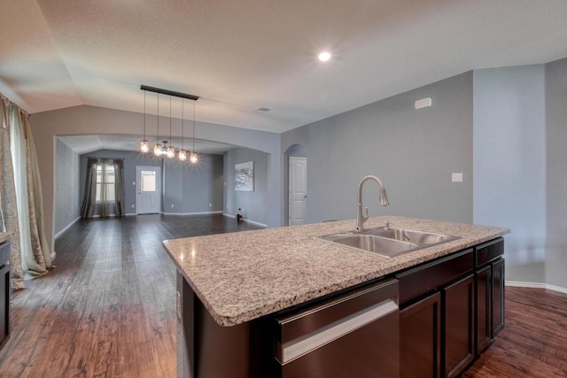 125 Lillian Dr, Taylor, TX 76574 - kitchen with dishwasher, dark wood finished floors, arched walkways, hanging light fixtures, and vaulted ceiling