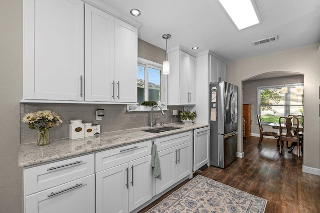 12403 Cassady Dr, Austin, TX 78727 - kitchen with stainless steel refrigerator with ice dispenser, dishwashing machine, arched walkways, decorative backsplash, and white cabinets