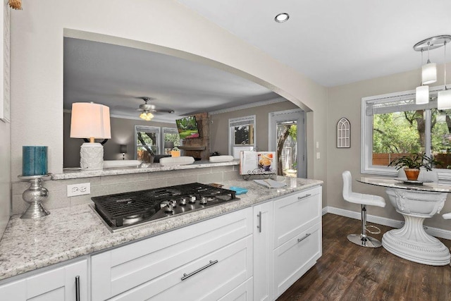 12403 Cassady Dr, Austin, TX 78727 - kitchen with arched walkways, stainless steel gas cooktop, a ceiling fan, white cabinets, and light stone countertops