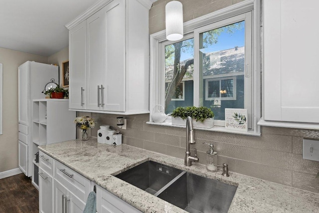 12403 Cassady Dr, Austin, TX 78727 - kitchen featuring white cabinetry, backsplash, light stone counters, and dark wood-style floors