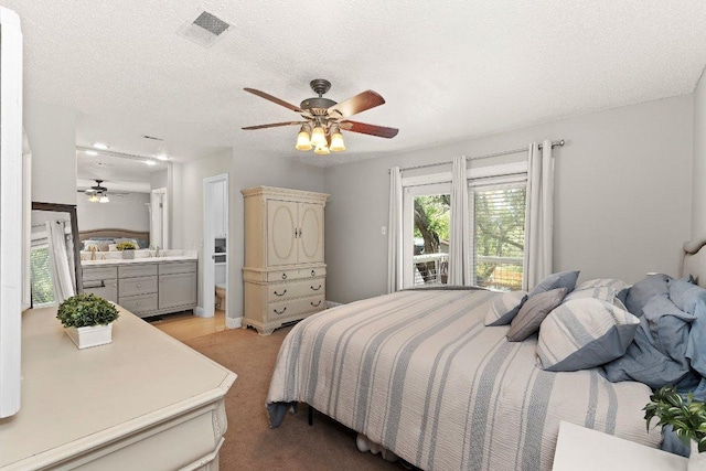 12403 Cassady Dr, Austin, TX 78727 - bedroom featuring light carpet, a textured ceiling, a ceiling fan, and ensuite bath