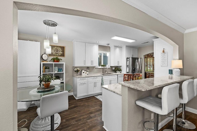 12403 Cassady Dr, Austin, TX 78727 - kitchen with stainless steel refrigerator with ice dispenser, dishwasher, arched walkways, dark wood finished floors, and light stone countertops