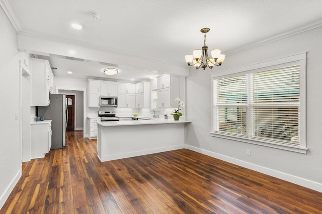 522 S Walnut Ave, Luling, TX 78648 - kitchen featuring appliances with stainless steel finishes, a chandelier, a peninsula, crown molding, and dark wood-style floors