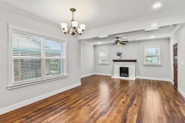 522 S Walnut Ave, Luling, TX 78648 - unfurnished living room featuring crown molding, healthy amount of natural light, a chandelier, wood-type flooring, and a fireplace